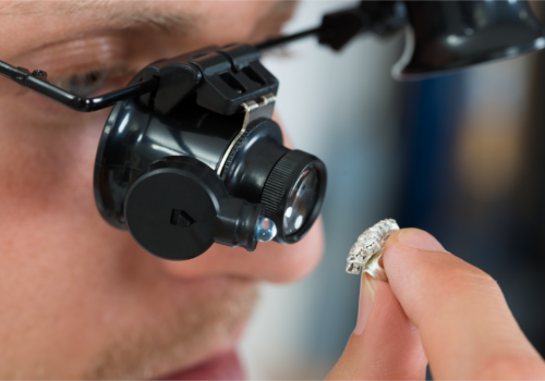 jeweler looking at diamond with loupe